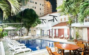 una piscina en un hotel con sillas y una mesa en Santorini Villas Santa Marta, en Santa Marta