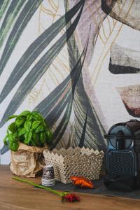 a table with a green plant and a wall at Olea Relais in Conversano