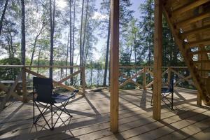 two chairs sitting on the deck of a cabin at Atpūtas komplekss Kalves in Mordanga +52 photos