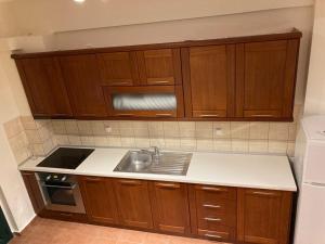 a kitchen with wooden cabinets and a sink at enJOY Golden beach in Skala Potamias