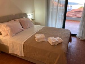 two towels sitting on a bed in a bedroom at enJOY Golden beach in Skala Potamias