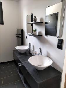 een badkamer met 2 wastafels en een spiegel bij A NOU'DEUX in Servas