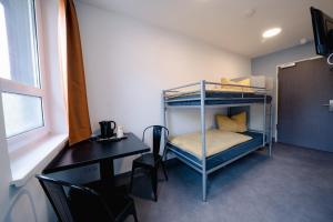 Pokój z biurkiem i łóżkiem piętrowym w obiekcie NeoHostel w Berlinie