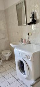 a bathroom with a washing machine and a sink at Apartment Living Leipzig in Großzössen