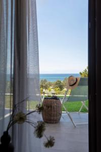 Habitación con ventana con silla y cesta en Heraclea Luxury Suites en Nea Iraklia