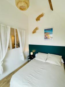 a bedroom with a white bed and a window at L'École Buissonnière - Dieppe centre-ville in Dieppe