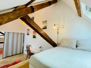 a bedroom with a bed and a desk in a room at L'École Buissonnière - Dieppe centre-ville in Dieppe