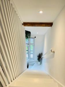 a staircase in a house with striped walls at L'École Buissonnière - Dieppe centre-ville in Dieppe