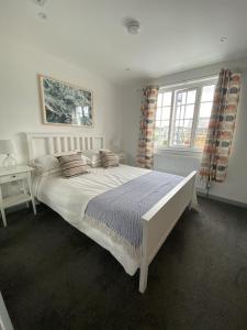 a bedroom with a large white bed with pillows at The Crows Nest - Sheringham in Sheringham