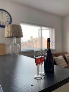 Dois copos de vinho e uma garrafa na mesa. em The Crows Nest - Sheringham em Sheringham