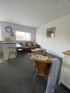 a living room with a couch and a table at The Crows Nest - Sheringham in Sheringham +17 photos