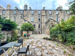 a large stone building with two chairs and a table at Remarkable 5BR Townhouse with Garden, Sleeps 12 in Edinburgh