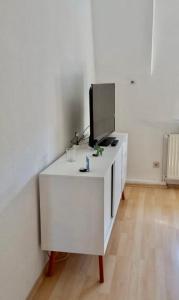 ein weißer Schrank mit einem Fernseher darüber in der Unterkunft Apartment Living Leipzig in Großzössen