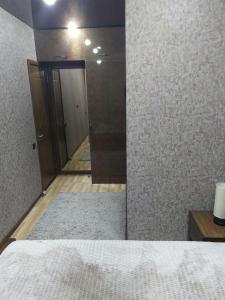 Zimmer mit einem Bett, einem Spiegel und einem Flur in der Unterkunft SALOUNIQUE Lux Apartment in Tbilisi City