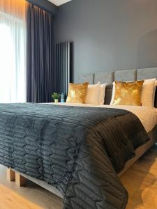 een groot bed met een zwart dekbed in een slaapkamer bij Unique Apartment Katowice City Center in Katowice