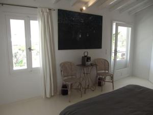 una camera da letto con tavolo, sedie e televisore a parete di Greek Island Guest House Samos Island a Samos