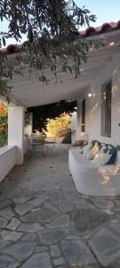 un divano bianco su un patio in pietra di Greek Island Guest House Samos Island a Samos