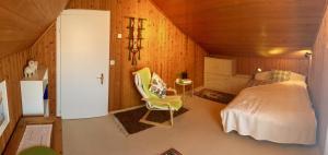 a bedroom with a bed and a chair in a room at Silvia's Bed und Breakfast in Luzern in Lucerne