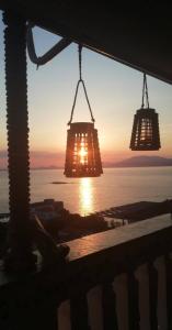 two lights hanging in front of a sunset at Panoramic Views Home in Hydra, Greece in Hydra