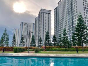 una piscina di fronte ad alcuni edifici alti di Affordable Staycation at COOL SUITES by SMDC Wind Residences a Tagaytay