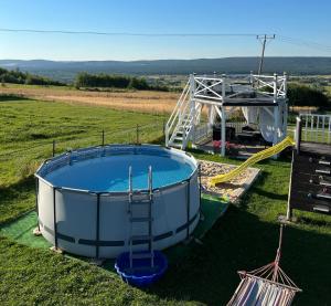 a large pool in the middle of a field with a slide at u Skiby in Krajno Pierwsze