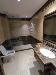 a bathroom with a toilet and a sink at Durrah Beach Apartment in Durat Alarous
