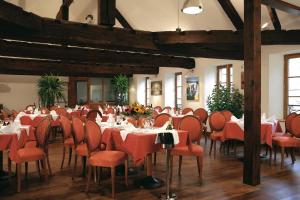 een eetkamer met rood beklede tafels en stoelen bij Le Saint Michel in Sedan