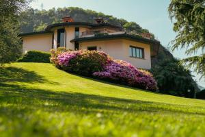 a house with flowers in front of a yard at Villa Dervio in Dervio