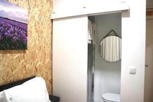 a bathroom with a toilet and a painting of purple flowers at Amadora Boutique Hostel in Amadora