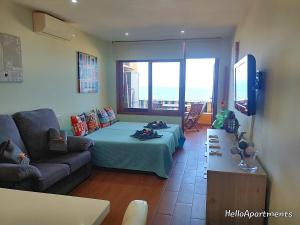 ein Wohnzimmer mit einem Bett und einem Sofa in der Unterkunft Sea View Playa Arena by HelloApartments in Puerto de Santiago