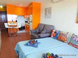 ein Wohnzimmer mit einem Bett und eine Küche in der Unterkunft Sea View Playa Arena by HelloApartments in Puerto de Santiago