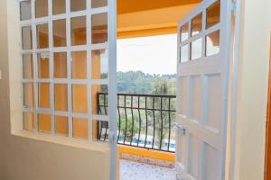 eine offene Tür mit Blick auf einen Balkon in der Unterkunft The Stay Comfort in Nyeri