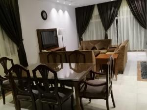 sala de estar con mesa, sillas y sofá en Durrah Beach Apartment en Durat  Alarous