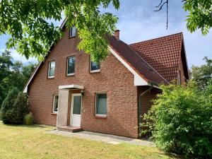 ein Backsteinhaus mit rotem Dach in der Unterkunft FeWo FriesenSPOt in Sankt Peter-Ording