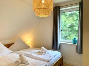zwei Einzelbetten in einem Zimmer mit Fenster in der Unterkunft FeWo FriesenSPOt in Sankt Peter-Ording