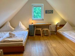 Schlafzimmer im Dachgeschoss mit 2 Betten und einem Schreibtisch in der Unterkunft FeWo FriesenSPOt in Sankt Peter-Ording