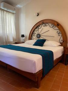 a bedroom with a large bed with a wooden headboard at Hotel Valle in Zihuatanejo