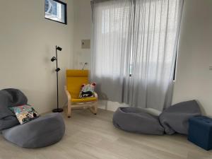 una sala de estar con 2 sofás y una silla en Tino House 全新開幕 質感包棟民宿 en Yilan City