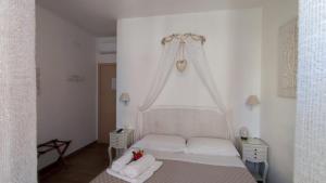 Un pequeño dormitorio con una cama blanca y una ventana en BeB Pignatelli Affittacamere en Matera