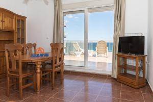 a dining room with a table and a view of the ocean at Pleno Sol, 45 in Cullera
