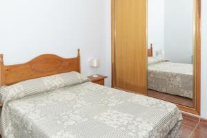 - une chambre avec un lit et un grand miroir dans l'établissement Pleno Sol, 45, à Cullera