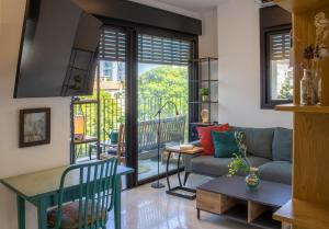 a living room with a couch and a balcony at Lovely 1-bedroom apartment in The best location in Tel Aviv