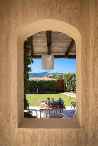 a view through an archway of a patio with a table at Residenza Grazia sul mare in Abbiadori