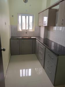 a kitchen with gray cabinets and a window at SWEET HOMES in Hyderabad