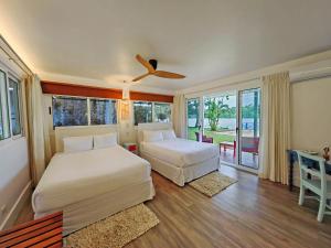 a bedroom with two beds and a balcony at Tortuga Lodge & Gardens by Böëna in Tortuguero