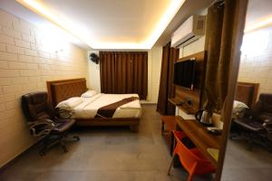 Zimmer mit einem Schlafzimmer mit einem Bett und einem TV in der Unterkunft Krish Garden in Chidambaram
