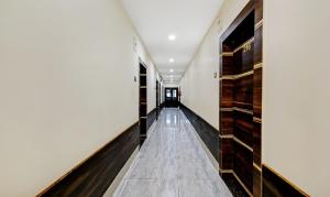 a long hallway with wood and marble floors and wooden cabinets at Treebo Spring Brook in Guwahati