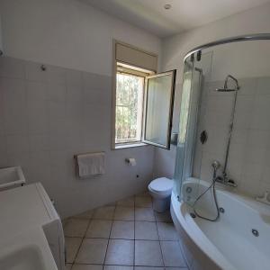 y baño con bañera, aseo y lavamanos. en Beach house, en Villaggio San Leonardo