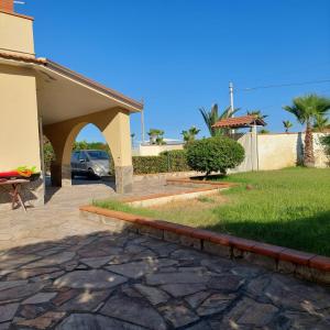 een huis met een patio en een oprit bij Beach house in Villaggio San Leonardo