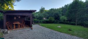un pequeño cobertizo de madera con un patio y un campo en La cabana bunicului, en Sibiu 5 fotos más